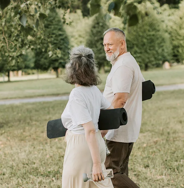 Senior couple walking together outdoors - healthy aging through comprehensive health monitoring
